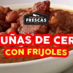 Pesuñas de Cerdo con Frijoles servidas en un plato hondo, con frijoles y verduras en salsa espesa.